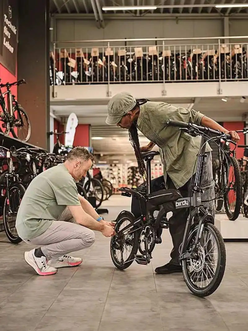 Fachhändler berät Kundin mit Klapprad