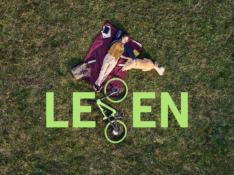 Glücklicher Fahrradfahrer liegt auf einer Wiese mit Hund